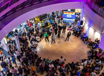 Viele Menschen im Foyer des Museums von oben fotografiert bei buntem Licht